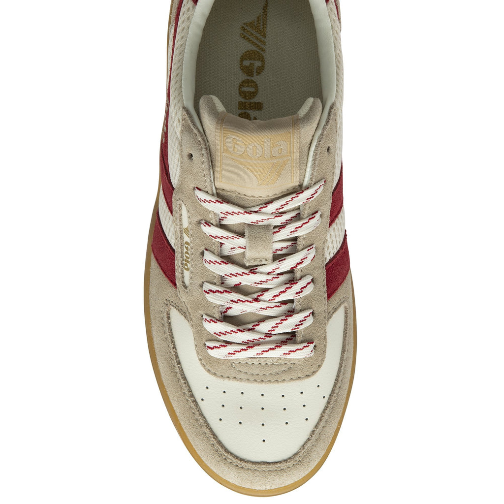 Close up of a Gola sneaker with a beige suede and white leather upper, red stripes, and white laces