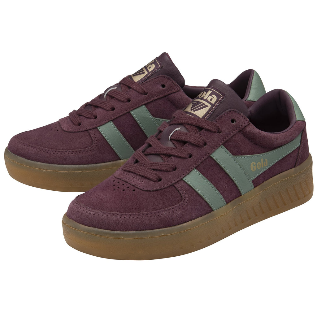 A pair of Gola low-top sneakers in burgundy with sage green stripes, side profile.