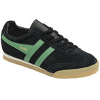 A black sneaker with green stripes and a light brown sole is shown from a 3/4 view.