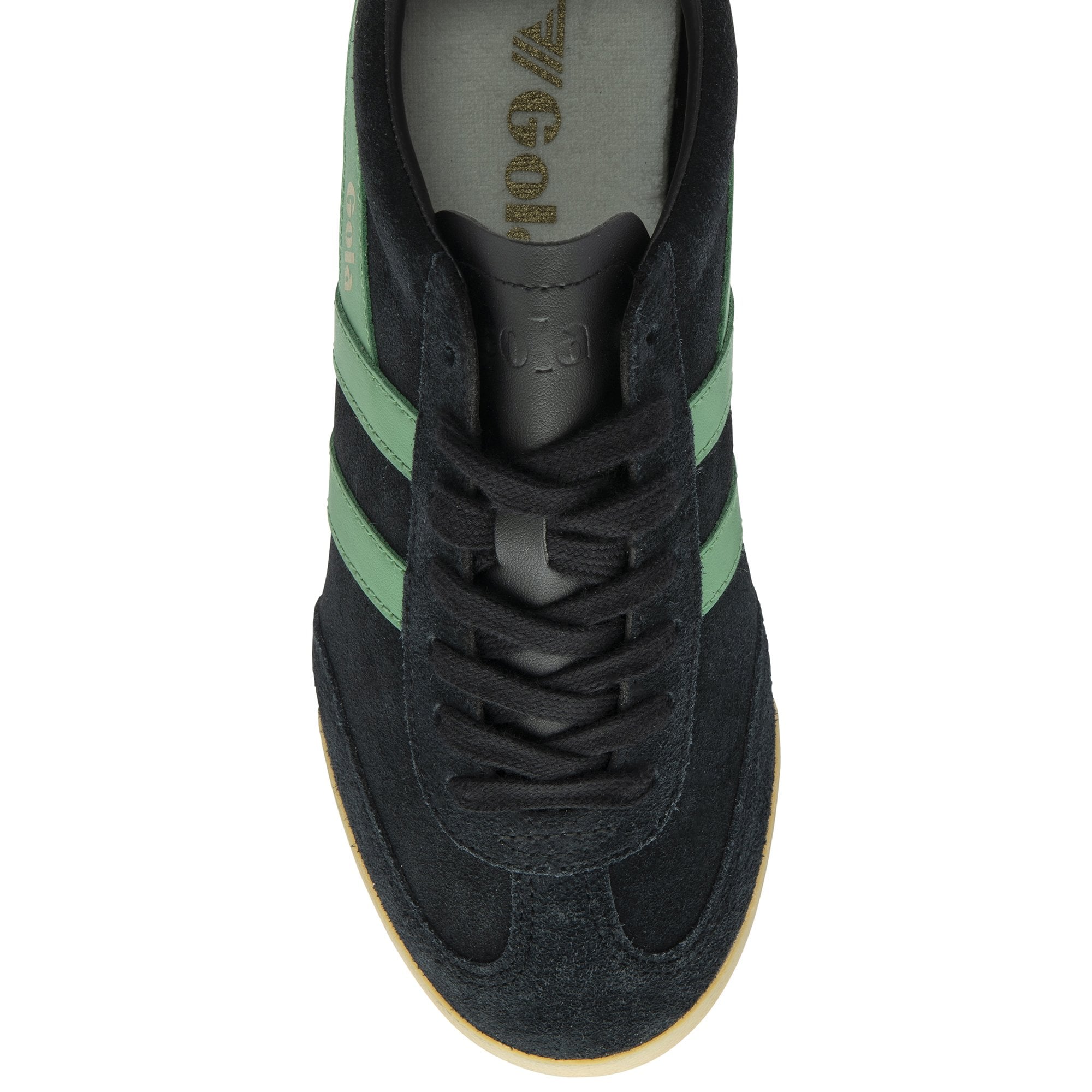 The top-down view of a black sneaker with green stripes and black laces.