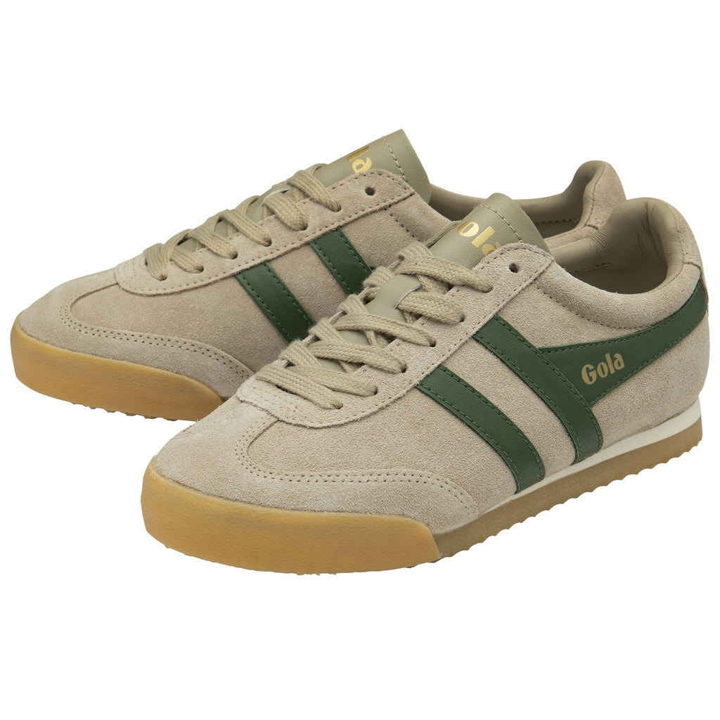 A pair of Gola Harrier trainers in tan with green stripes, viewed from an angle.