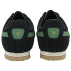 The back view of a pair of black sneakers with green accents and light brown soles.