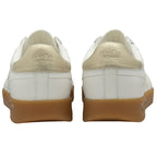 The backs of two white and gold Gola sneakers with gum soles, showing the logo.