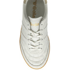 An overhead view of a white and gold Gola sneaker with a gum sole, showing the laces.