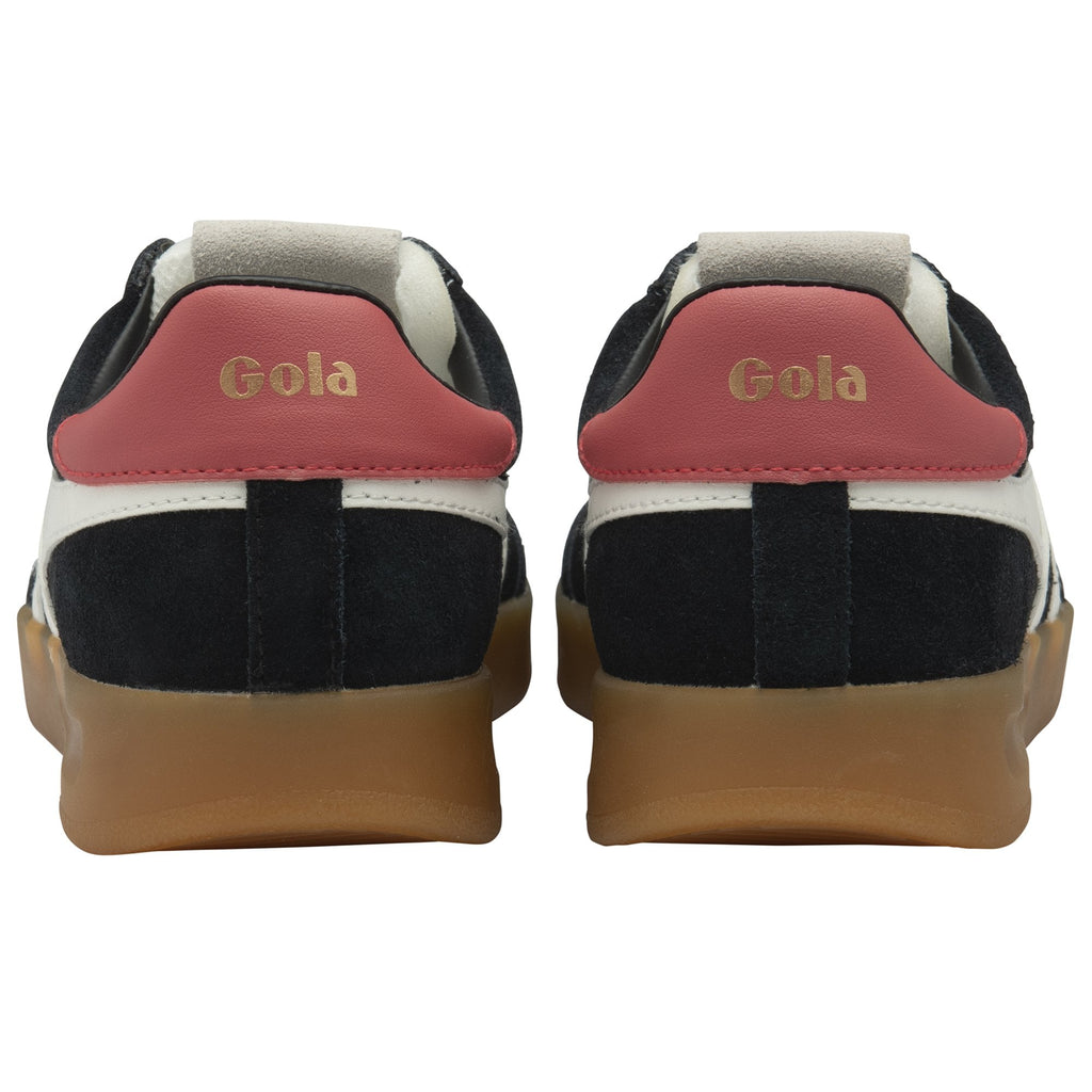 The back view of a pair of black sneakers with red heels and gum soles.