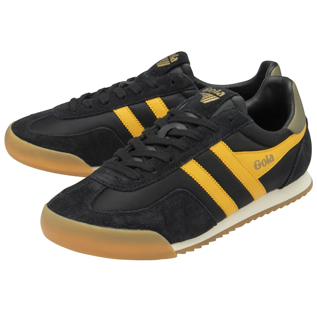 Pair of black and gold Gola sneakers with gum soles, one slightly behind the other.
