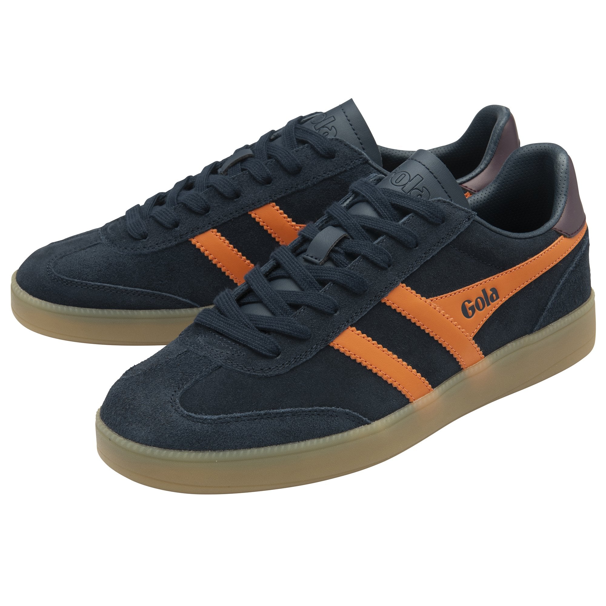 A pair of Gola trainers, angled view, dark blue with orange stripes and brown sole.