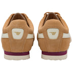 Pair of tan suede sneakers with white stripes and purple soles, seen from the back.