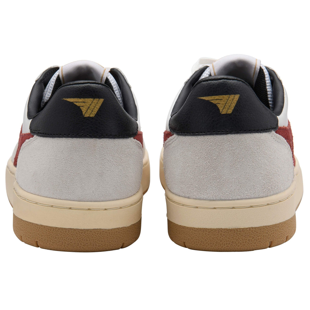 Rear view of two white, red, and black trainers with a gold logo on the heel