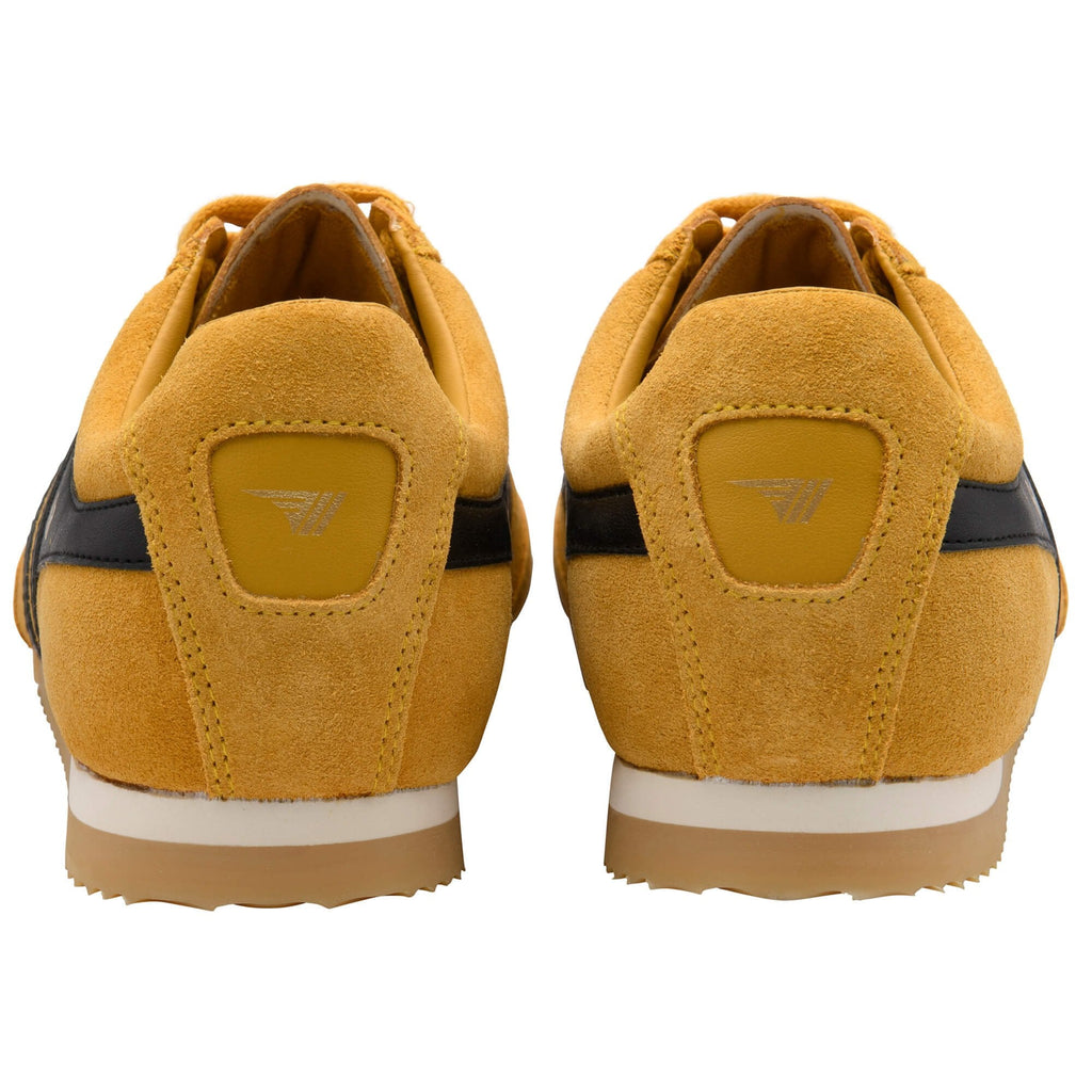 Pair of yellow trainers with Gola logo on the back on a white background