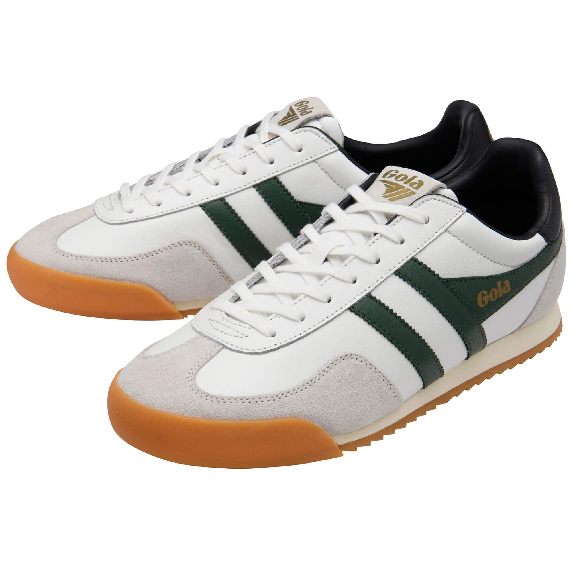 White trainers with green stripes and gum soles on a white background