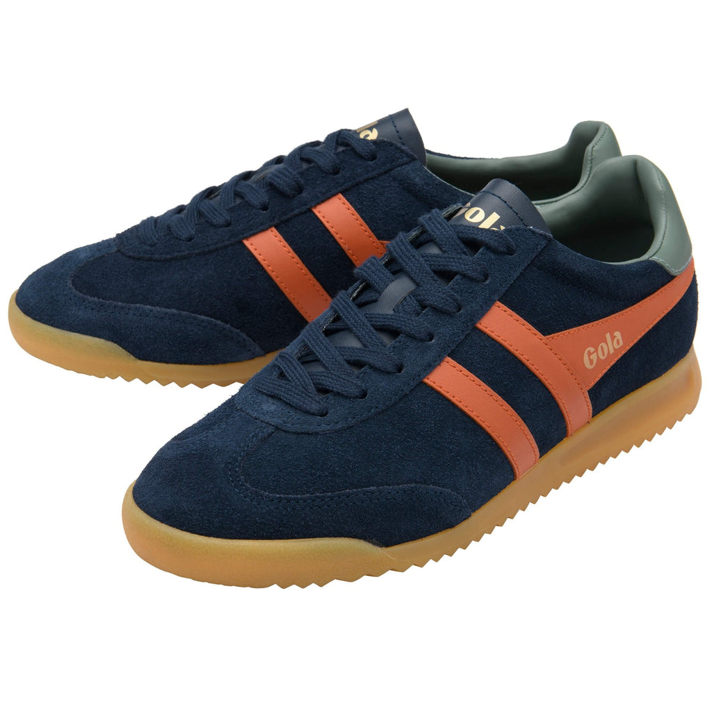 Navy trainers with orange stripes and brown soles on a white background