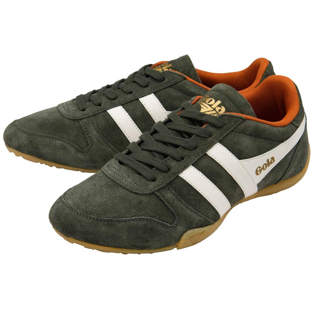Green trainers with white stripes and orange lining on a white background