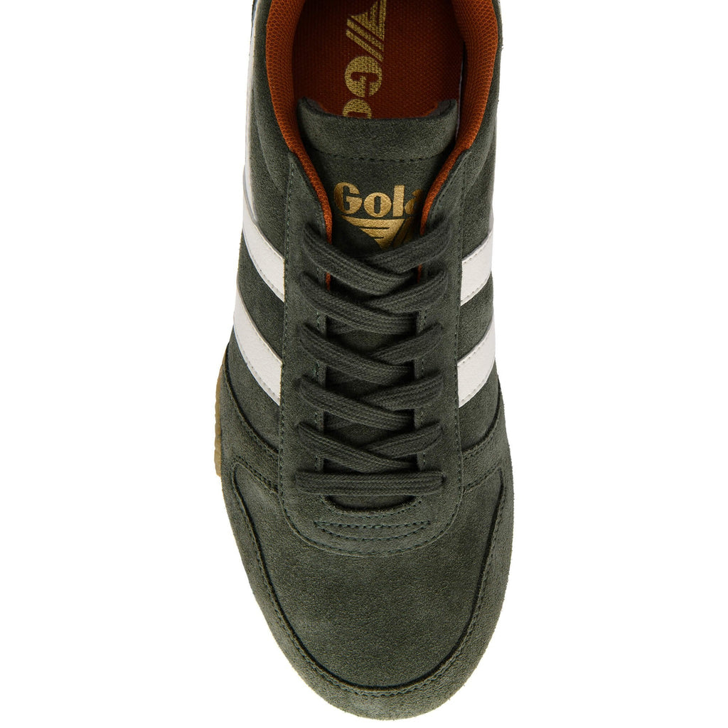 Top-down view of a dark green suede trainer with white stripes and orange lining