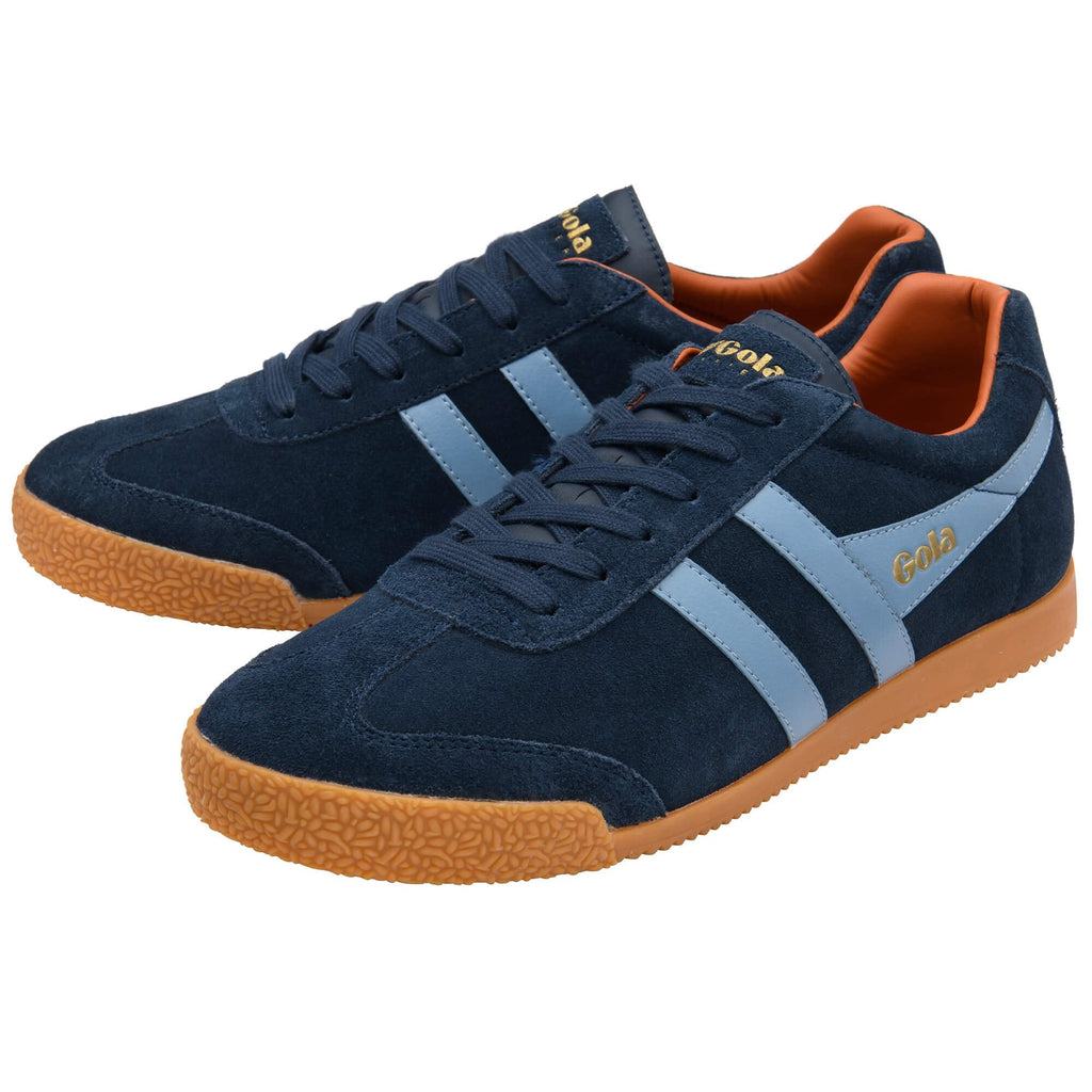 Pair of navy blue trainers with brown soles on a white background