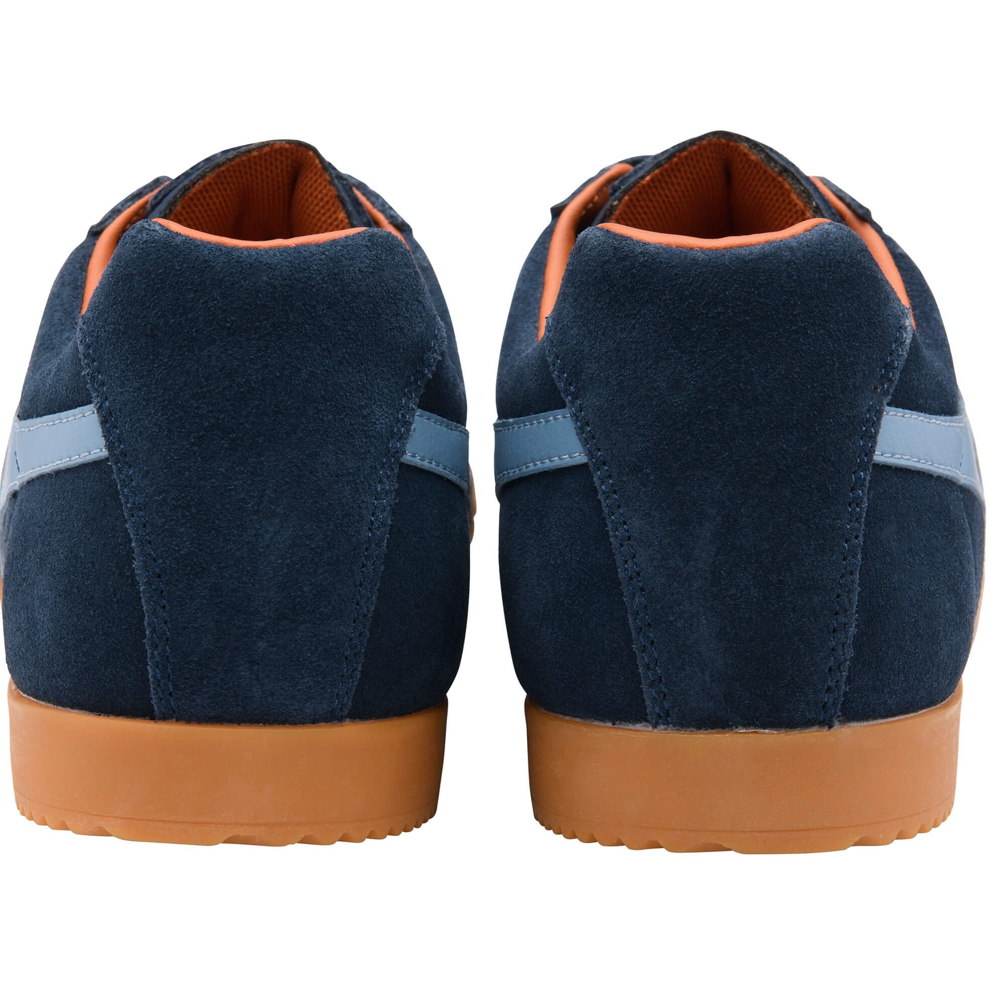 Pair of navy blue suede trainers with brown soles on a white background
