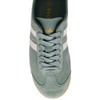 Close up of a Gola trainer in green suede with white stripes and laces on a white background