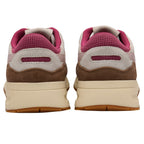 Pair of trainers with brown, pink, and beige colour scheme on a white background