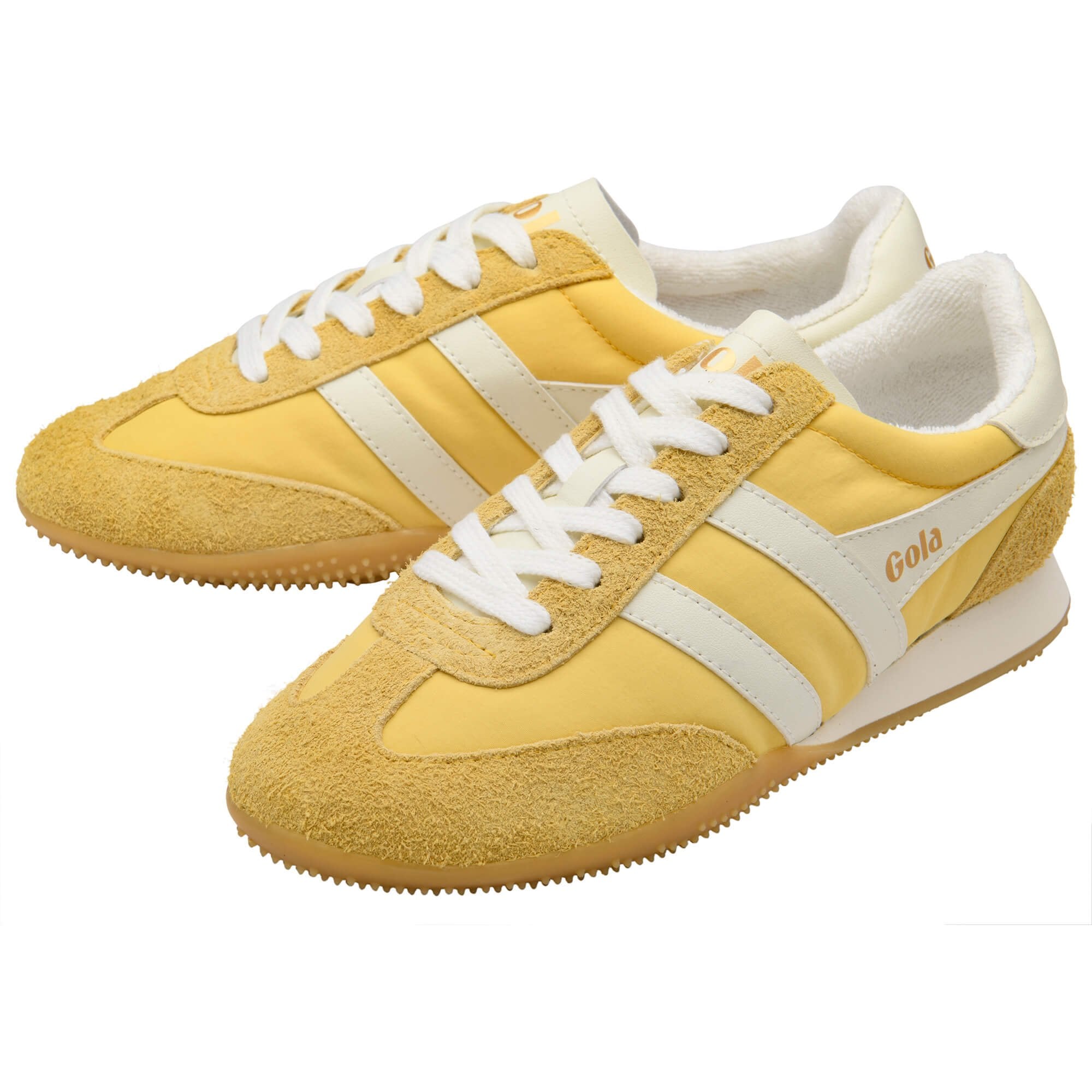 Yellow trainers with white laces and sole on a white background