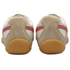 Pair of beige and white trainers with red stripes and gum soles, seen from the back