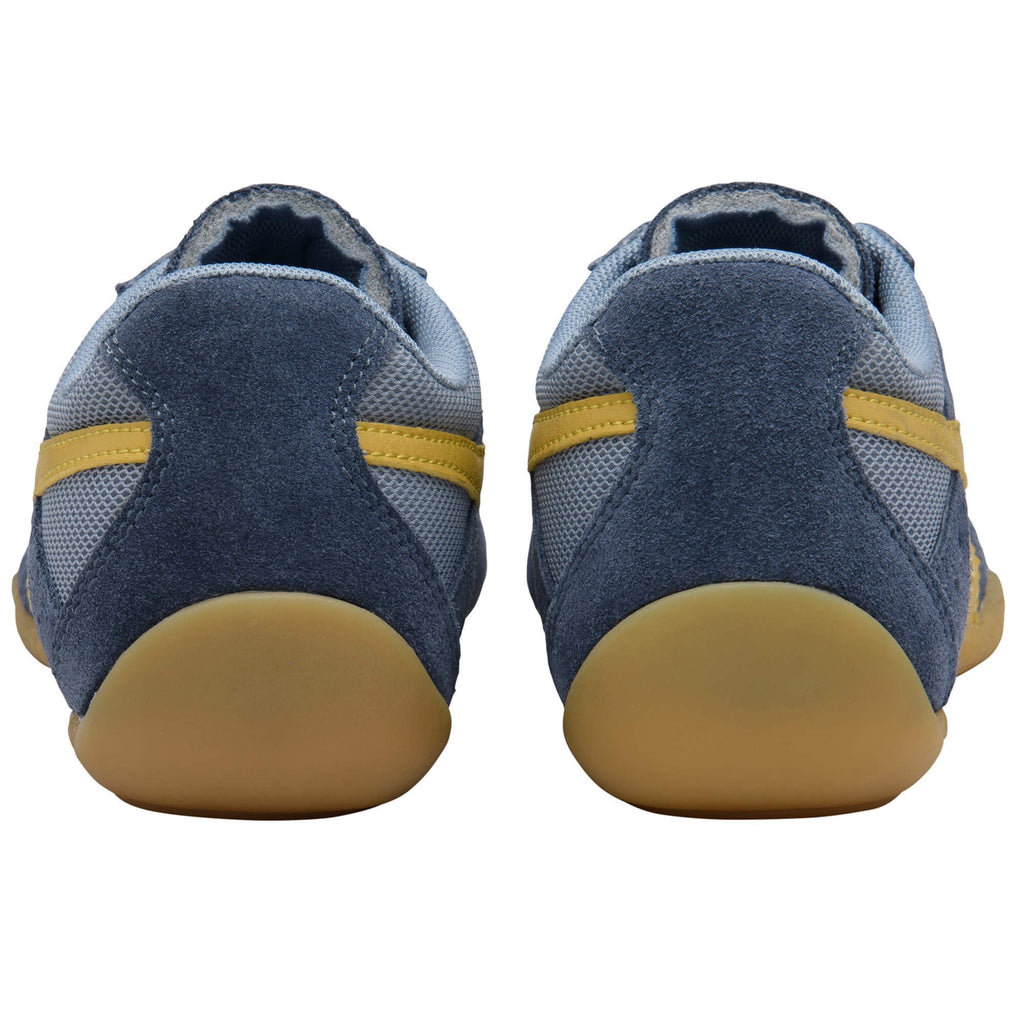 Pair of blue trainers with yellow accents on a white background