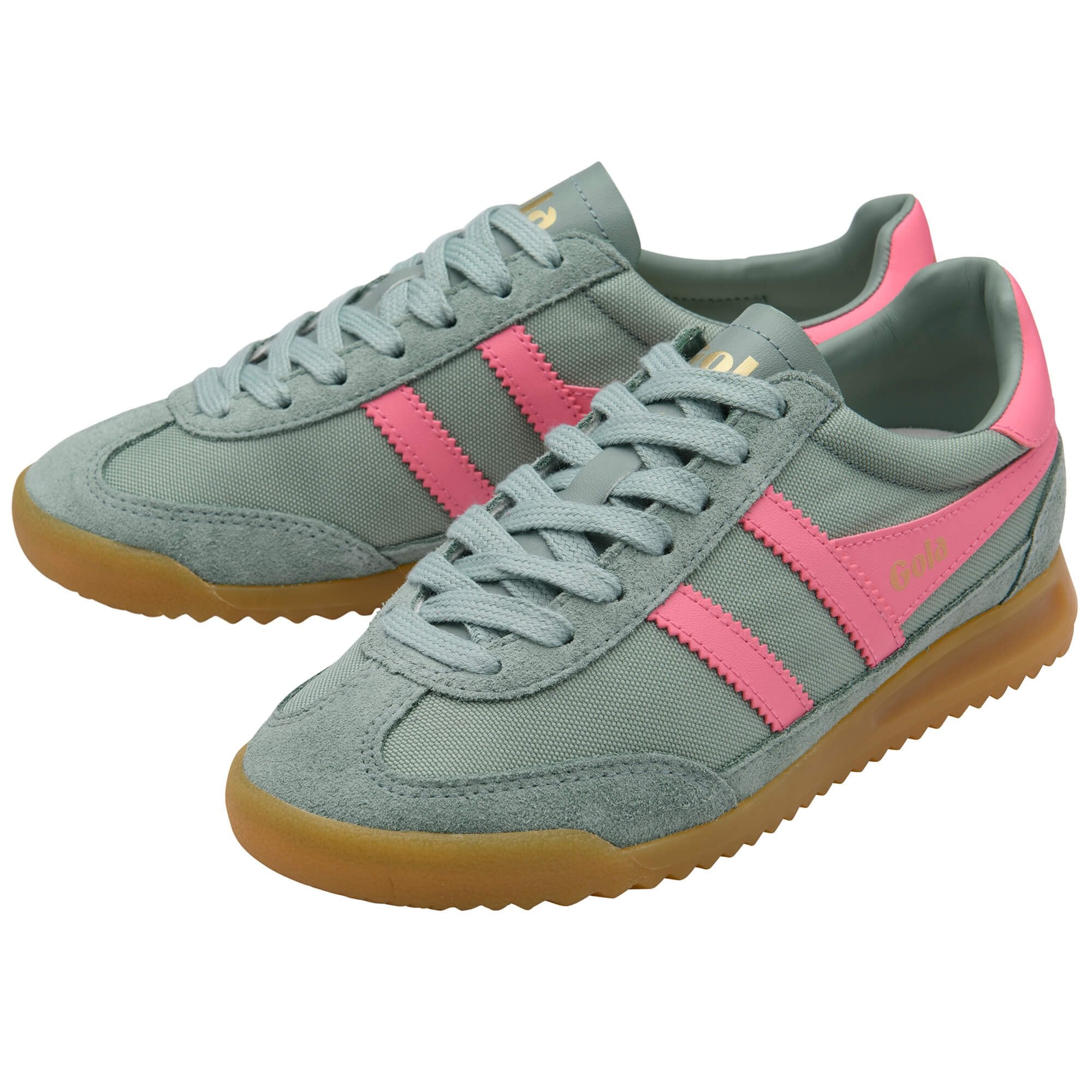 Green trainers with pink stripes and gum soles on a white background