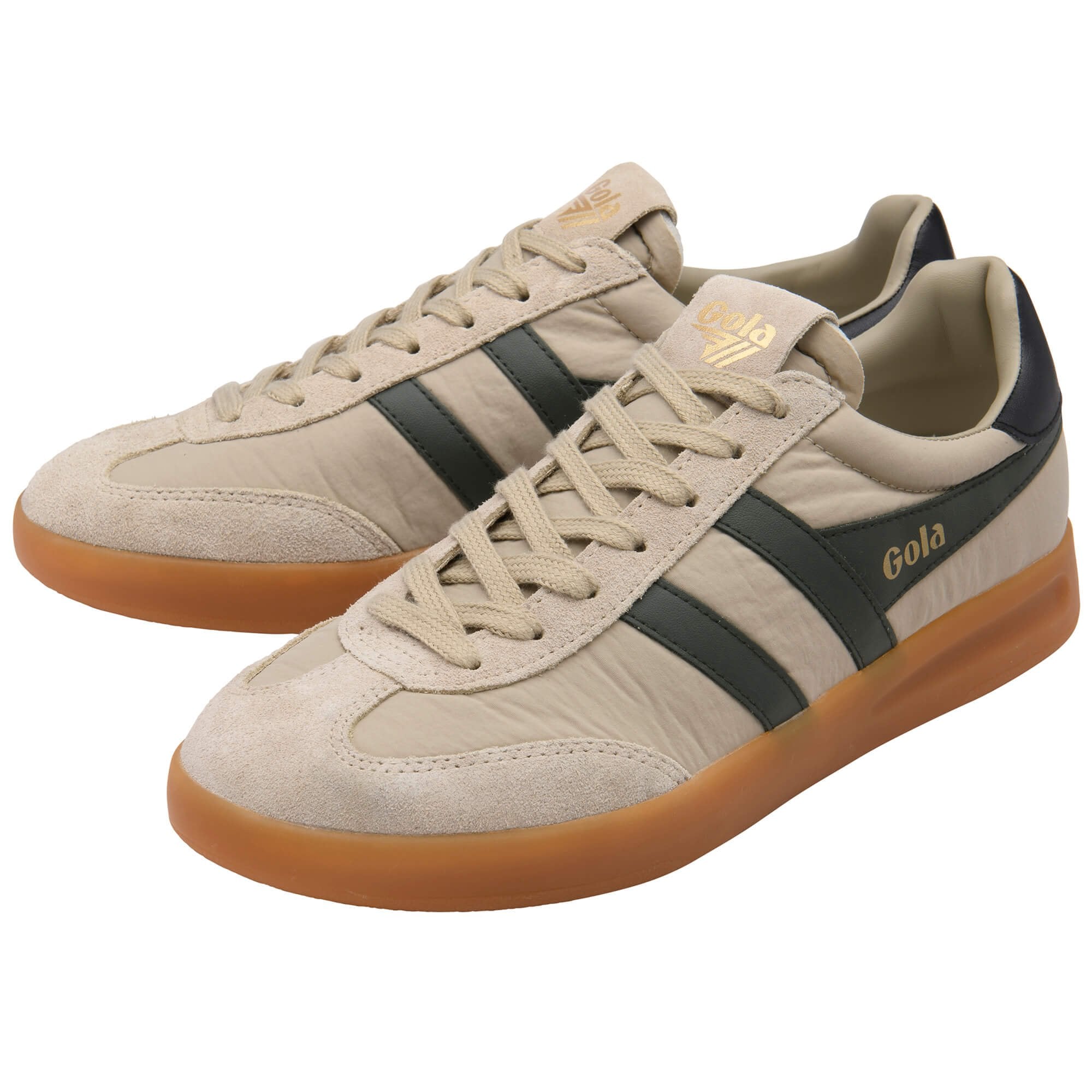 Beige trainers with black stripes and brown soles on a white background