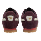 Pair of burgundy suede trainers with white stripes and gold logo on the heel