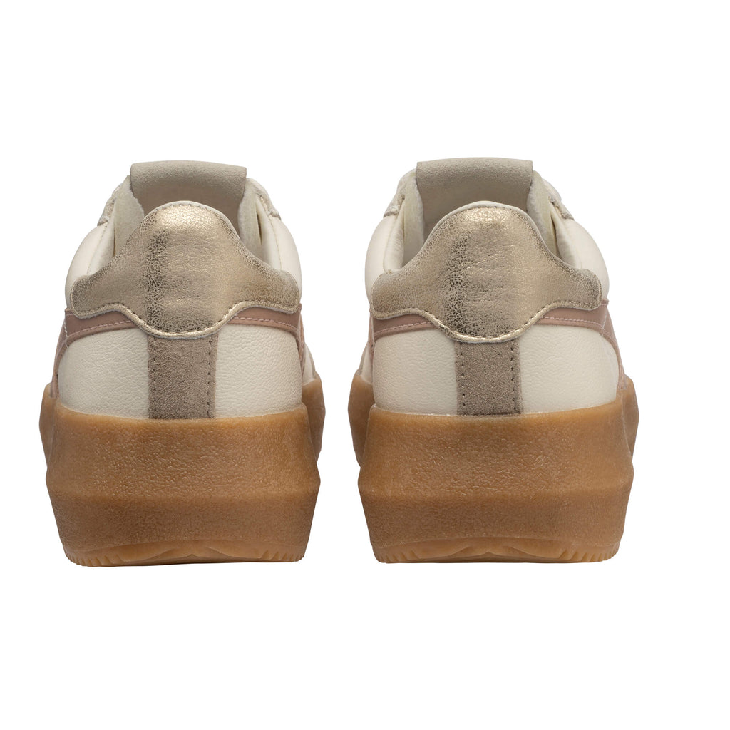 Pair of white and gold trainers with brown soles, rear view