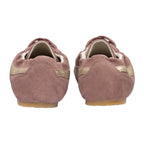 Pair of pink suede ballet slippers with gold stripes, seen from behind
