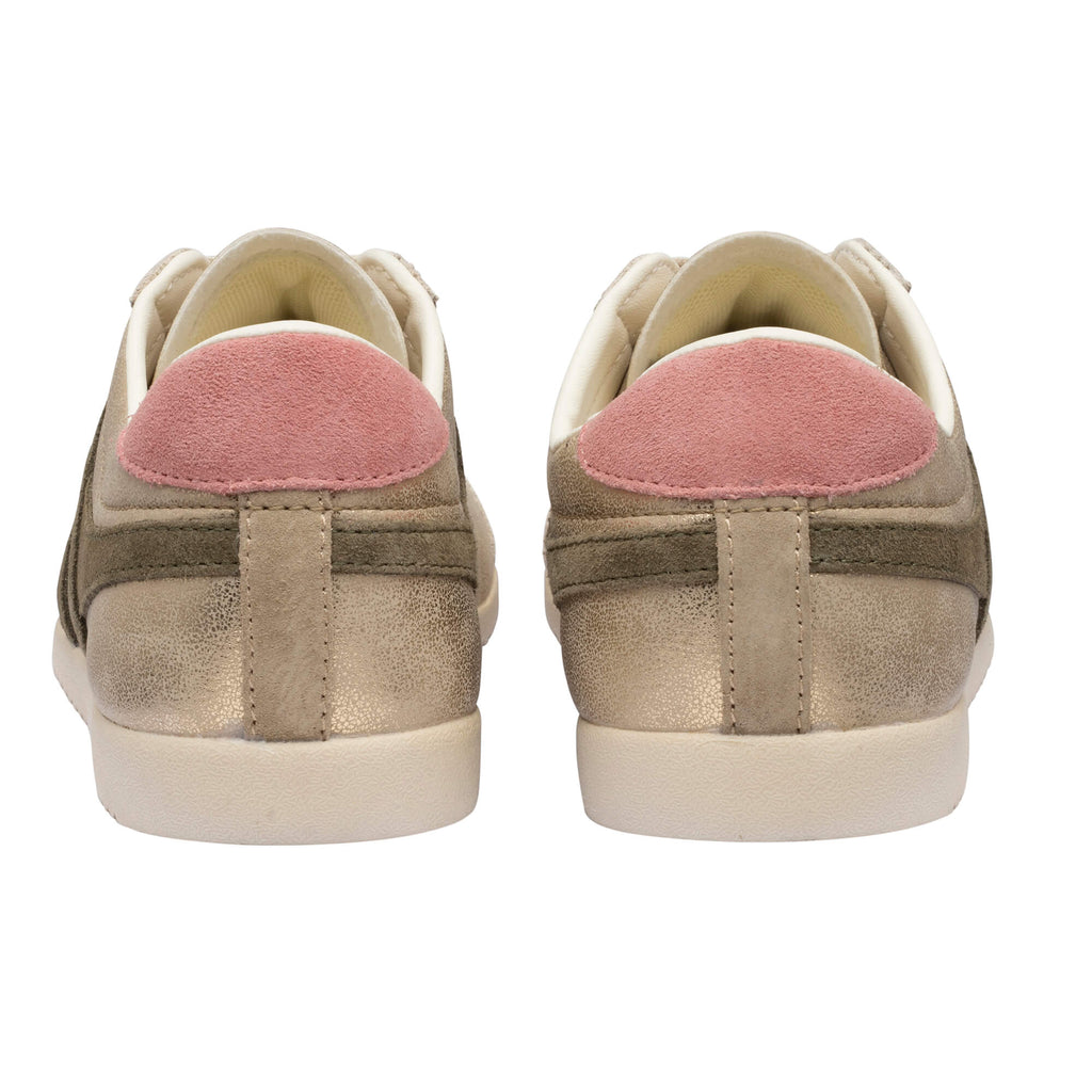 Rear view of two gold trainers with pink suede heel tabs and cream soles