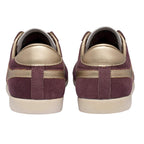 Pair of burgundy suede trainers with gold accents, rear view