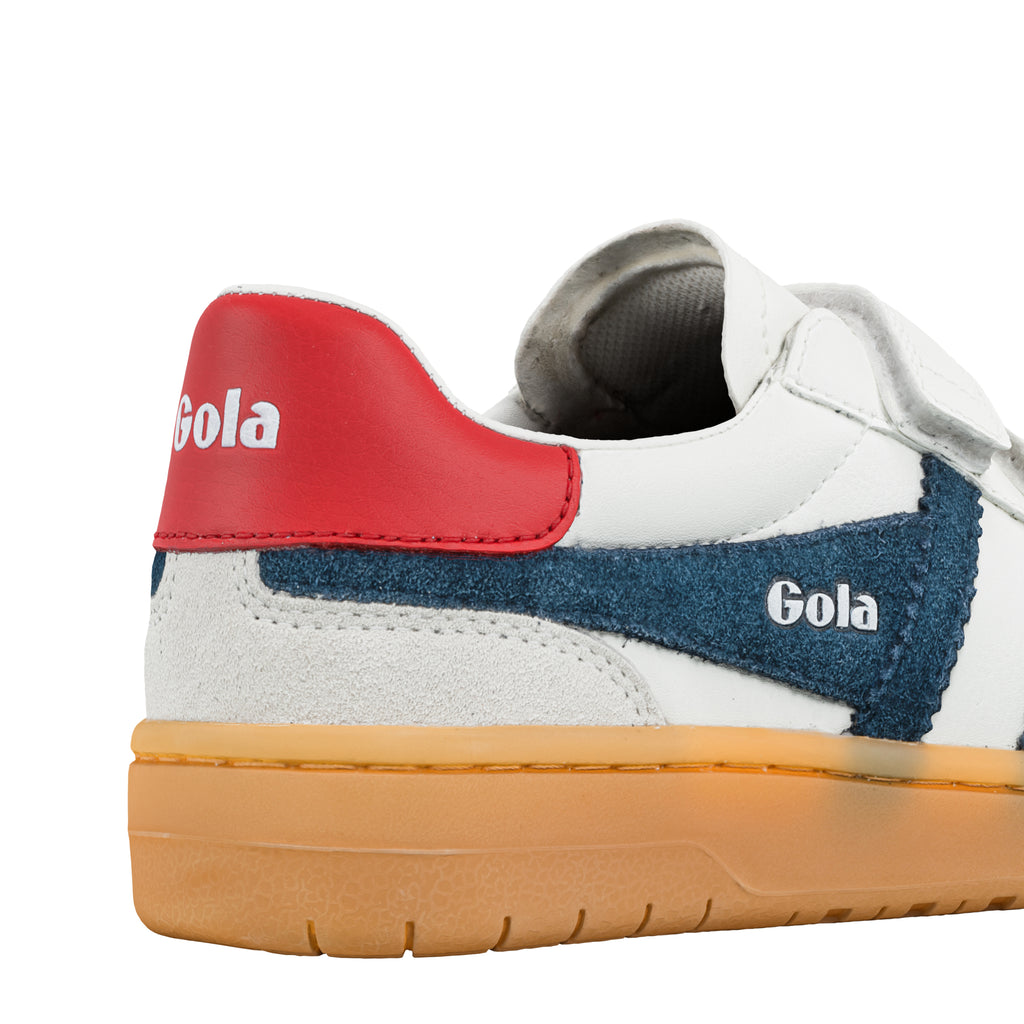 Close up of white Gola trainer with red heel tab and blue suede side panel on a gum sole