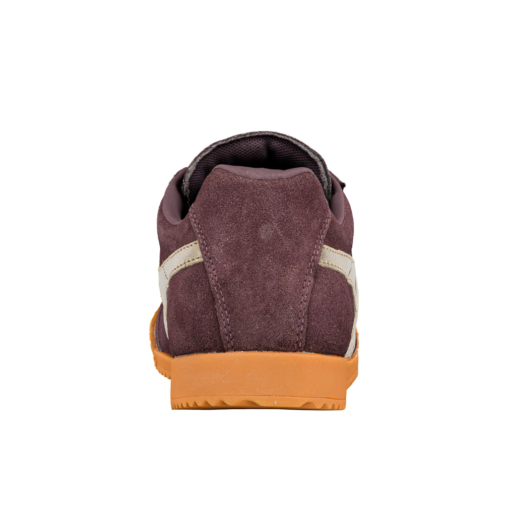 Rear view of a burgundy suede trainer with a gum rubber sole