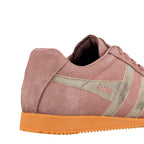 Close up of the heel and side of a pink suede trainer with metallic gold detailing and a gum sole