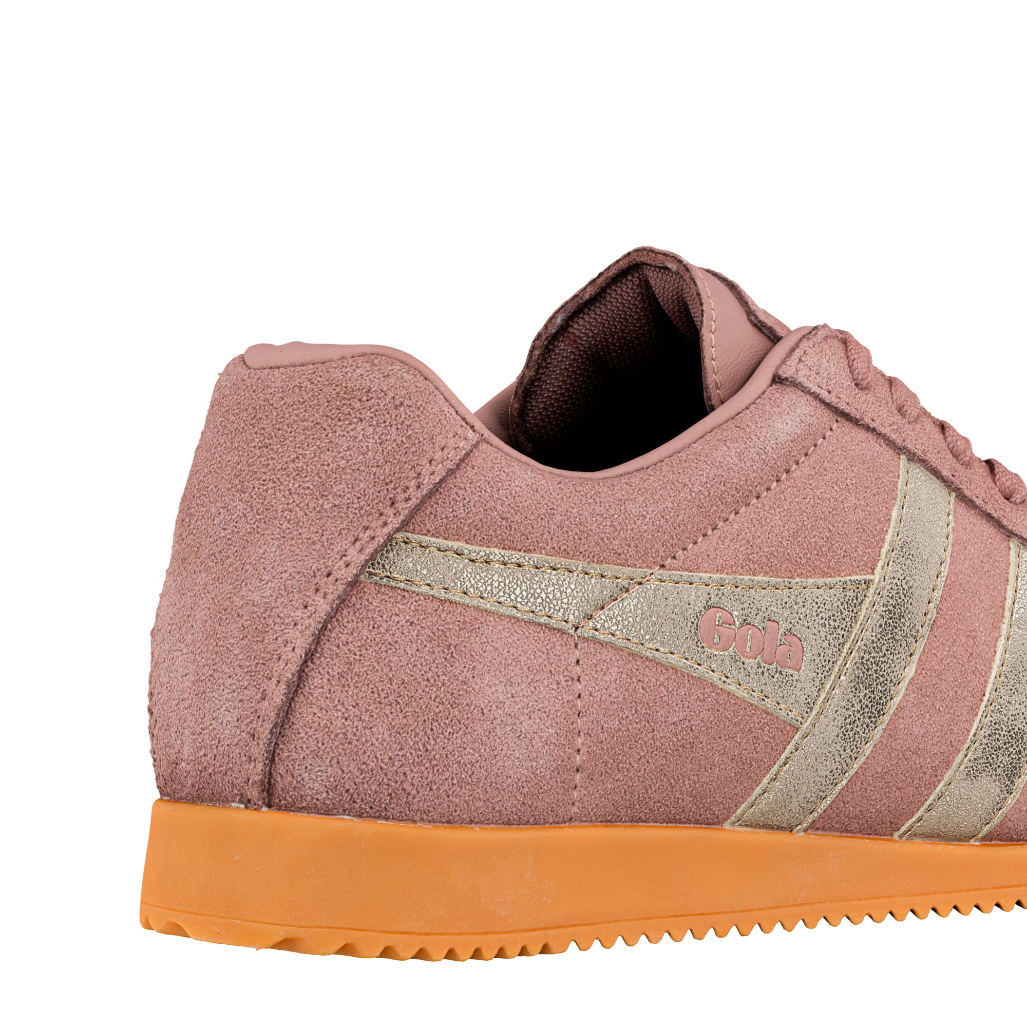 Close up of the heel and side of a pink suede trainer with metallic gold detailing and a gum sole