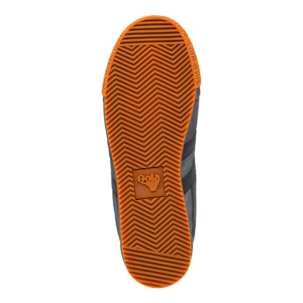 Orange rubber sole of a Gola trainer with a chevron tread pattern