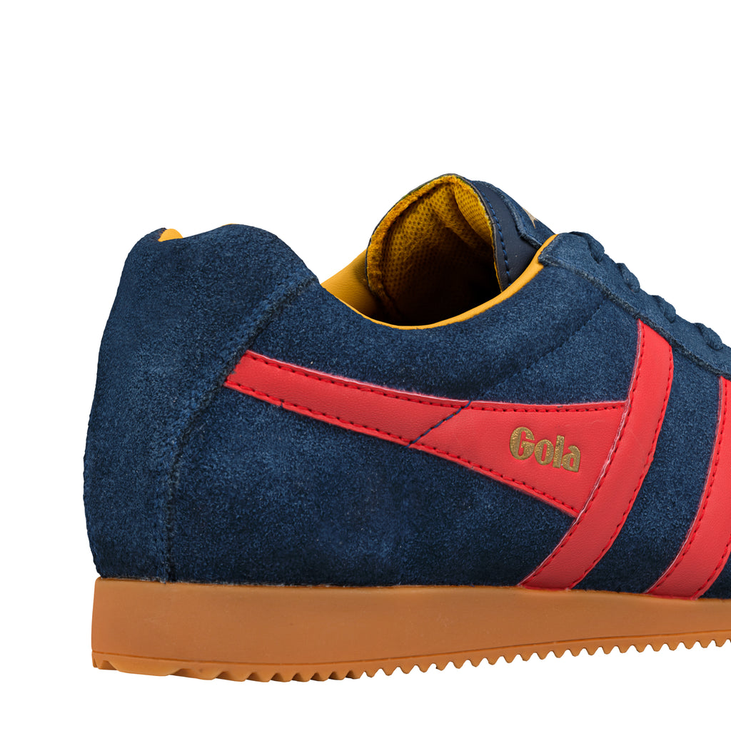 Close up of navy blue suede Gola trainer with red side stripes and gum sole