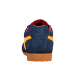 Rear view of a navy blue suede trainer with yellow side stripes and a gum rubber sole