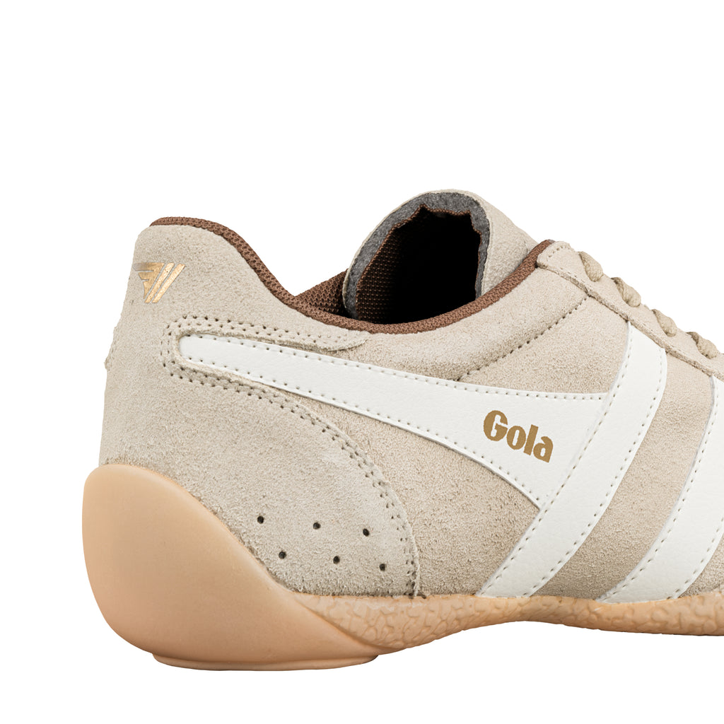Close up of the heel and side panel of a beige suede Gola trainer with white side stripes