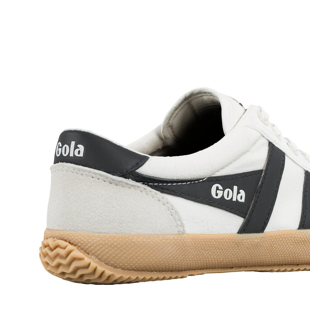 Rear view of a white canvas Gola trainer with a gum sole and black branding