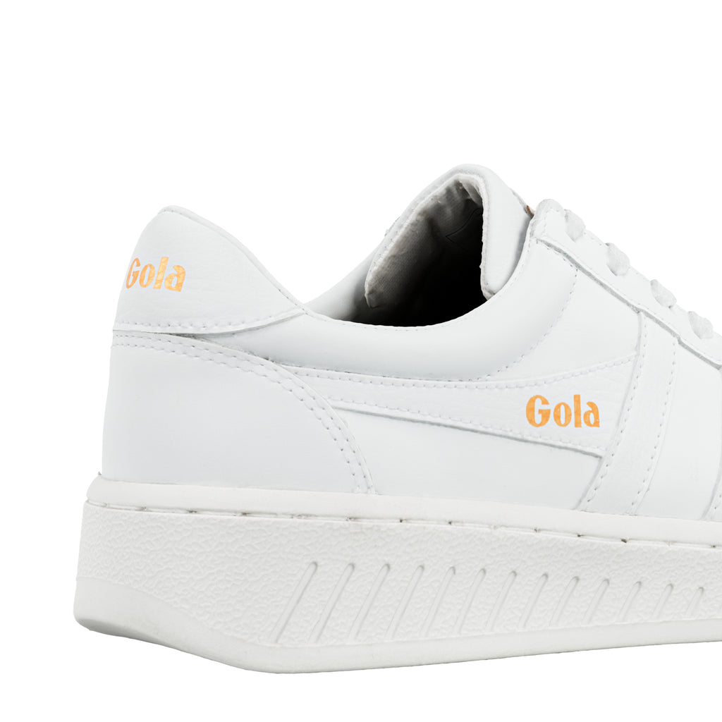 Close up of the heel and side of a white Gola trainer with gold branding