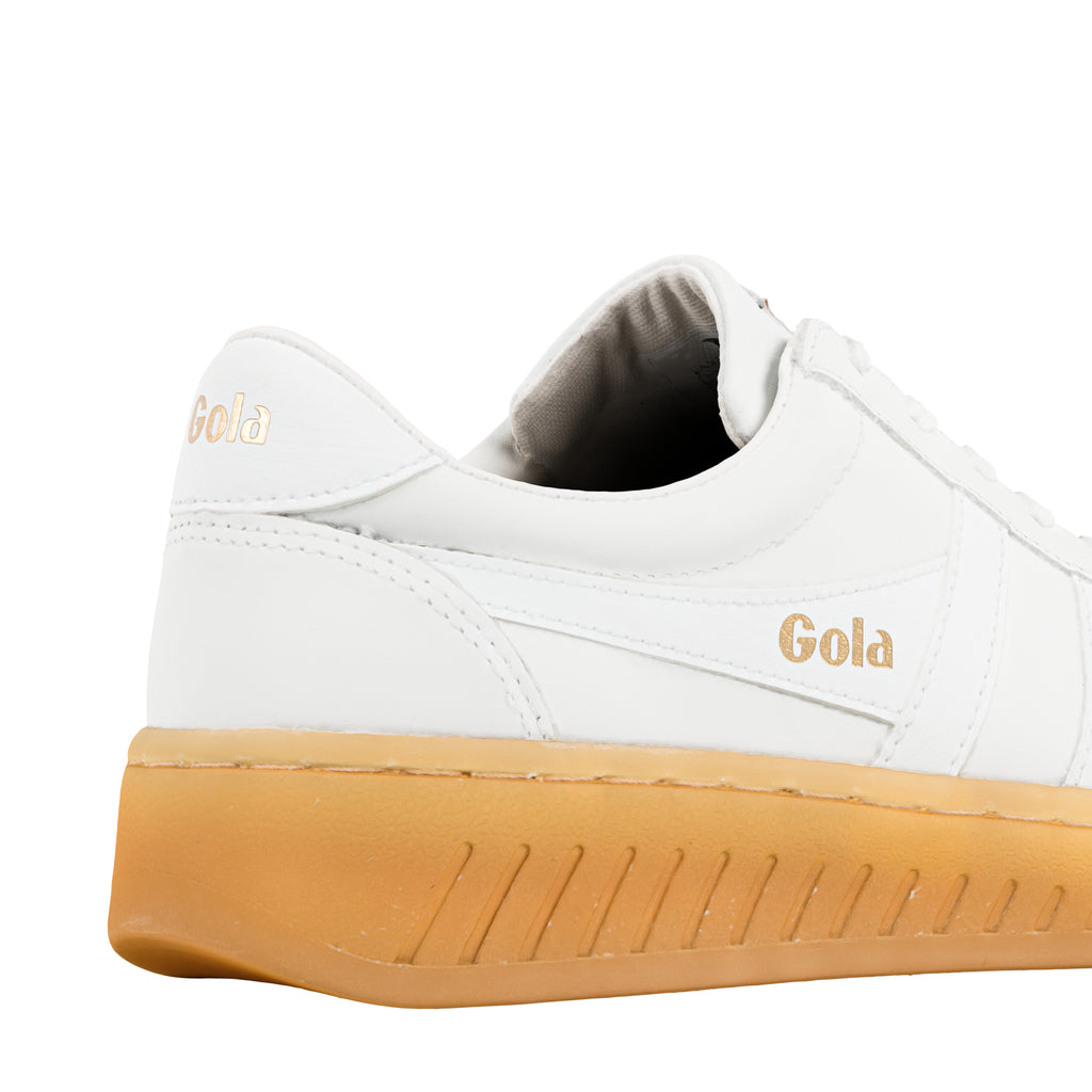 White Gola trainer with gold branding and gum sole