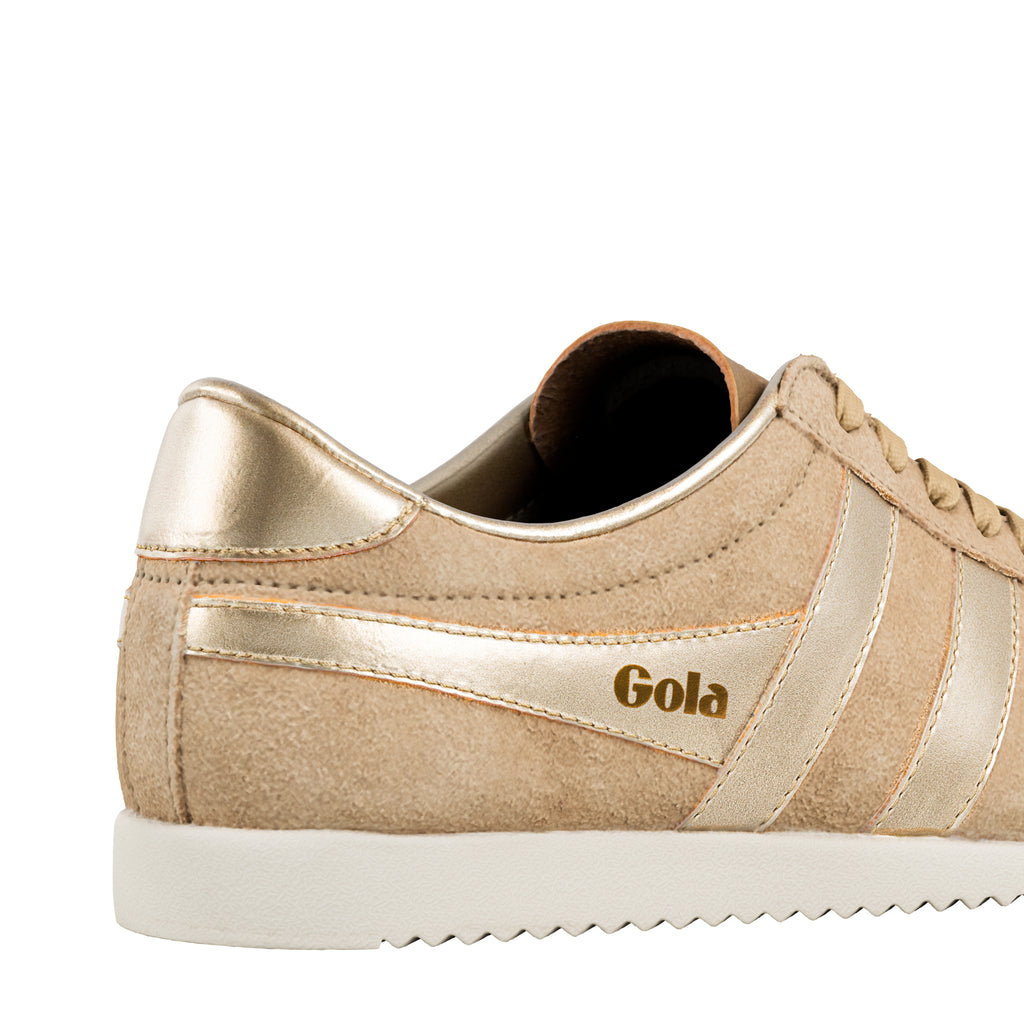 Close up of a beige suede Gola trainer with metallic gold detailing