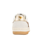 Rear view of a white and beige trainer with a metallic gold heel tab and brand logo