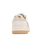 Rear view of a white and beige suede trainer with a gum rubber sole and gold logo detail