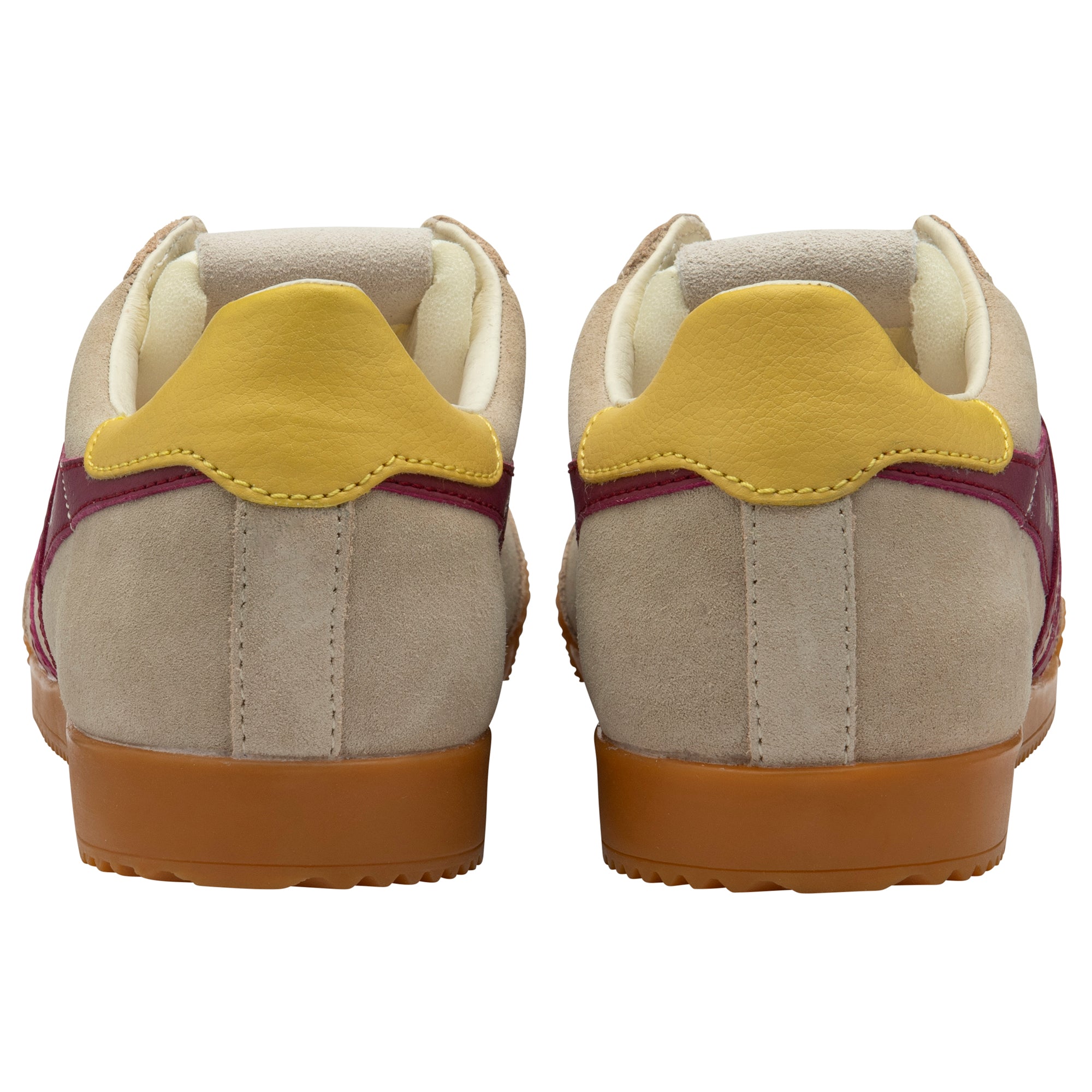 Pair of beige trainers with yellow heel tab on a white background