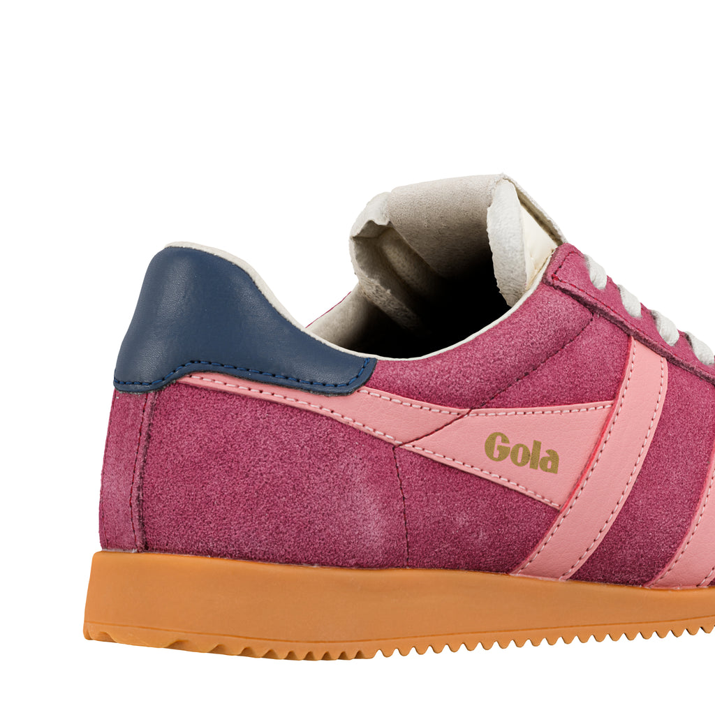 Rear section of a pink suede Gola trainer with a navy heel tab and gum sole