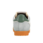 Rear view of a light grey suede trainer with a green heel tab and orange rubber sole