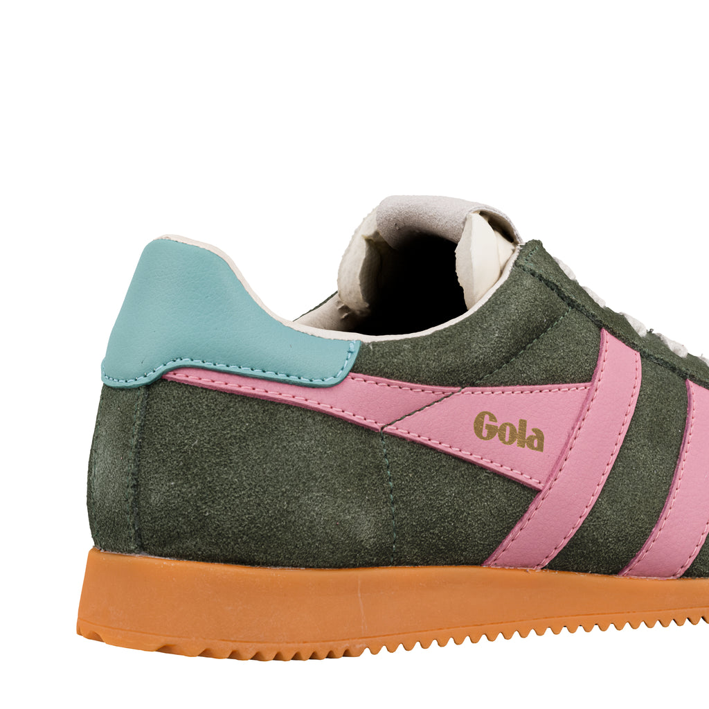 Close up of a green suede Gola trainer with pink side stripes and a turquoise heel tab on an orange sole